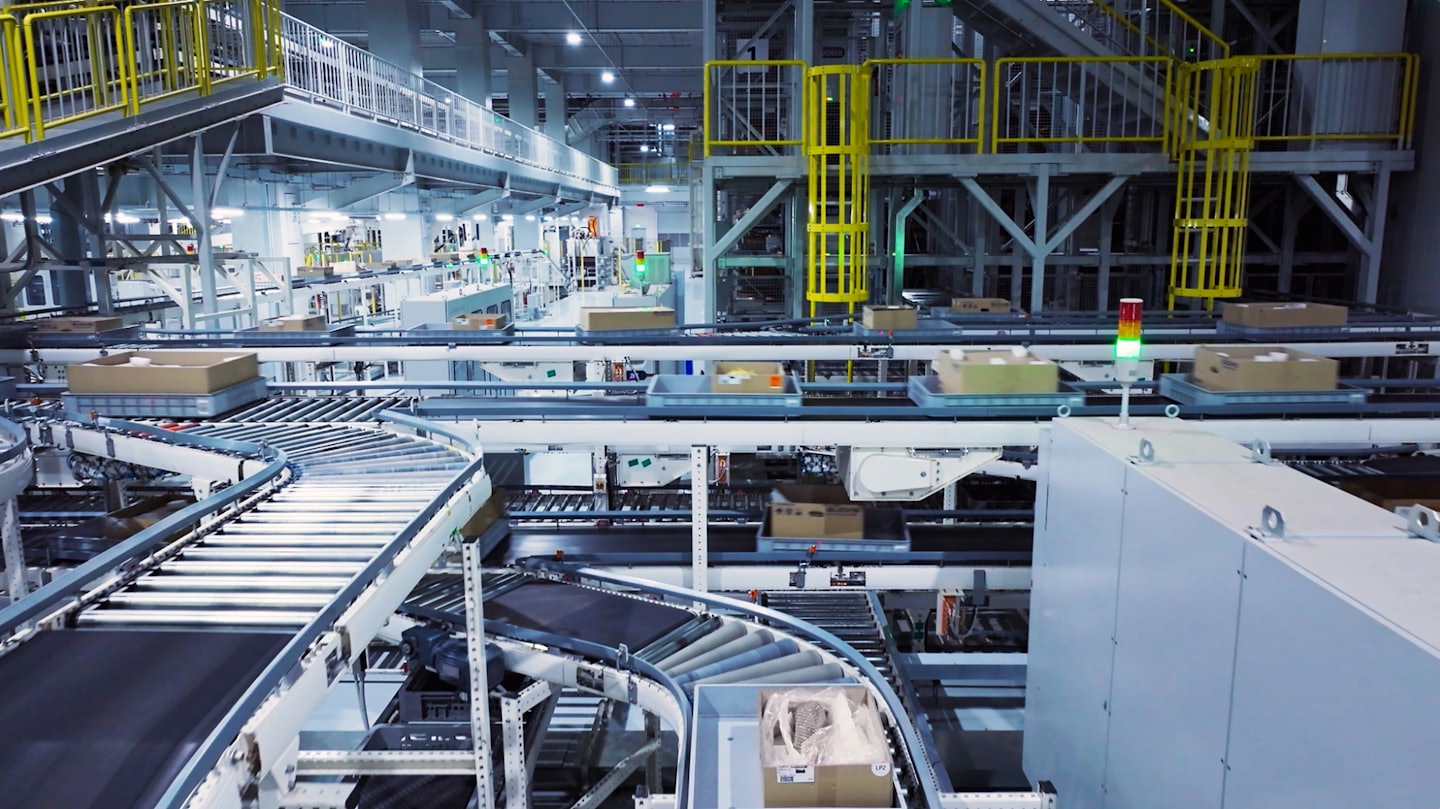 Automated conveyor system in a busy warehouse with boxes.