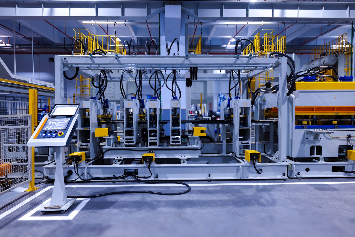 Automated robotic arms working on a machine in a factory.